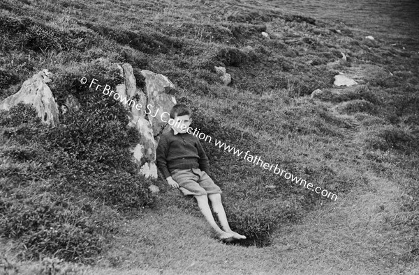 GLENCOLUMBKILLE BOY SITTING BY ROCK